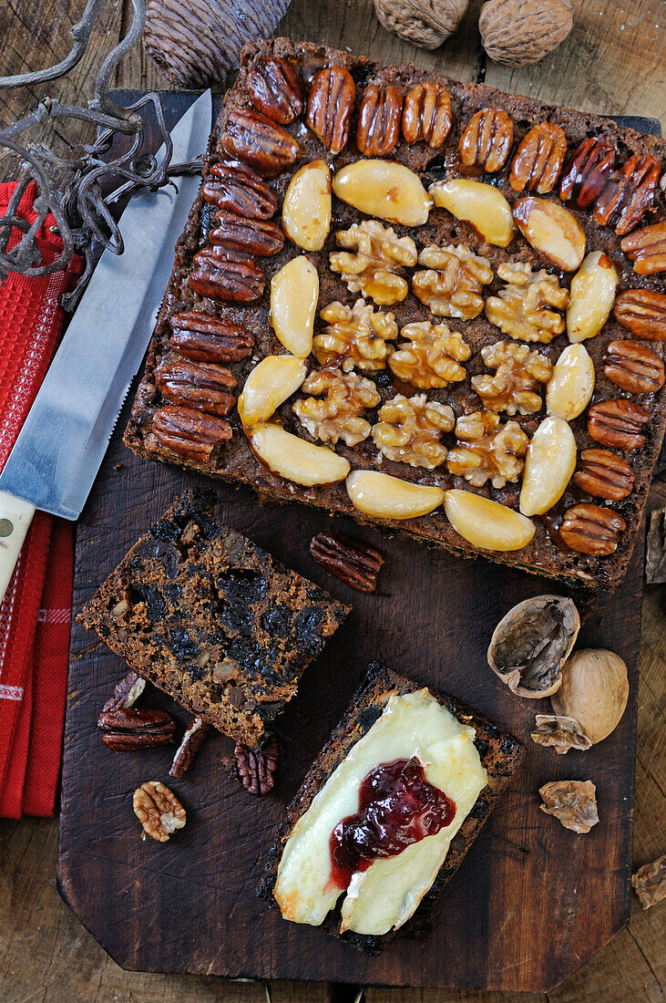 Traditioneller Weihnachtskuchen mit Trockenfrüchten und Nüssen, mit Brie und Marmelade