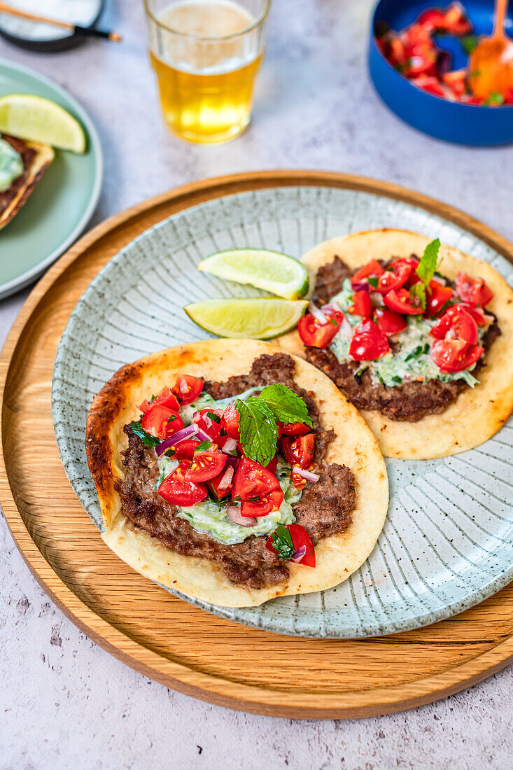 Smash tortillas with ground lamb, tzatziki and tomato salad