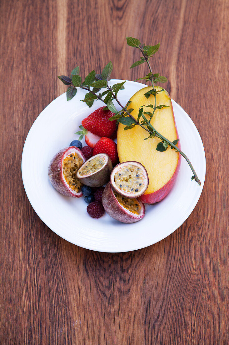 Frisches Obst (Beeren, Mango, Passionsfrucht) und Pfefferminze