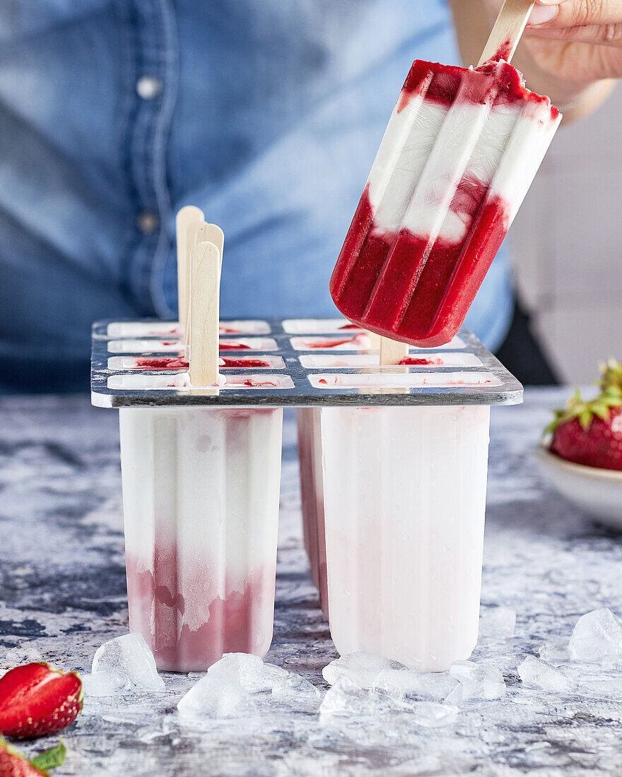 Strawberry and coconut ice cream on a stick