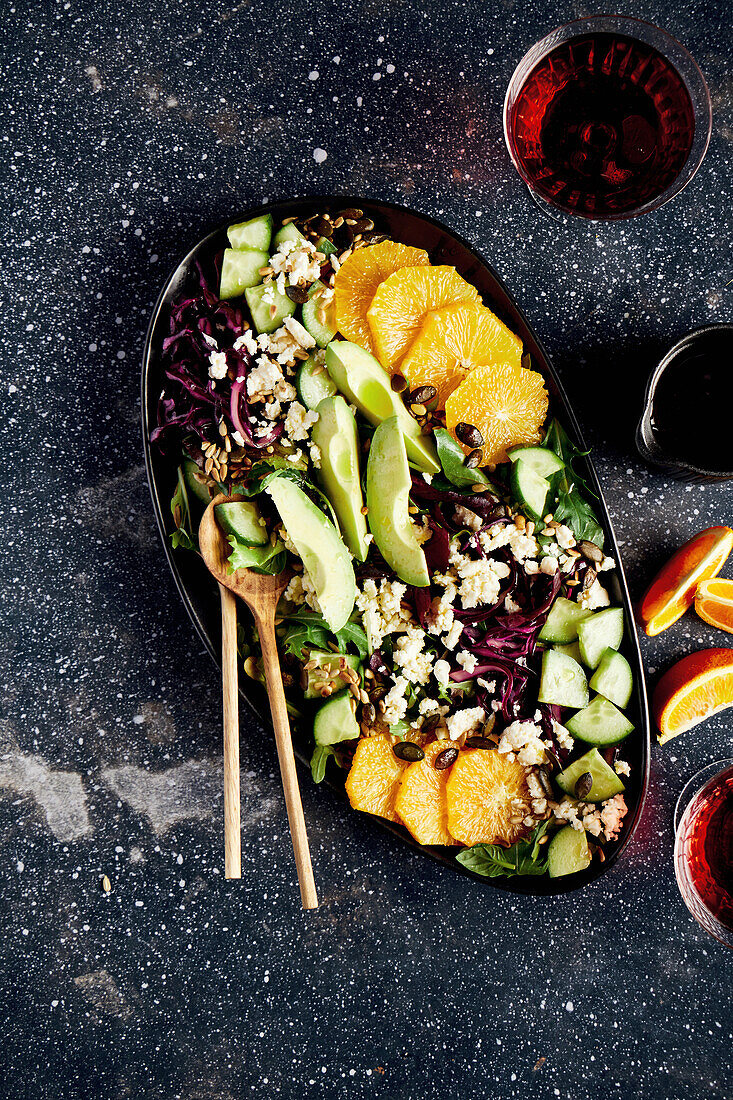 Salat mit Orangen, Gurke, Rotkraut, Avocado und Feta