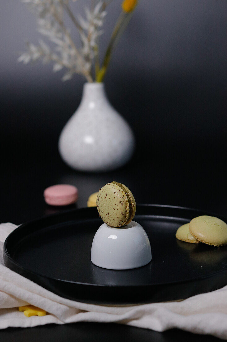 Still life with macarons, ceramic dish and vase