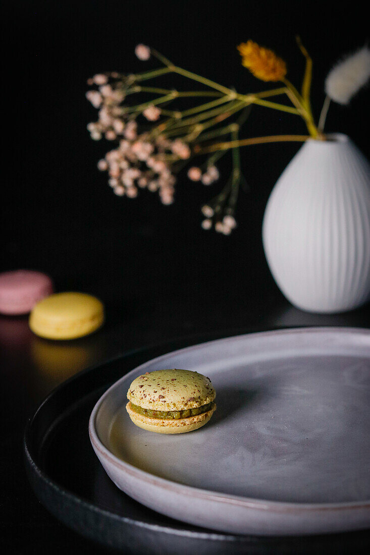 Still life with macarons, ceramic plate and vase