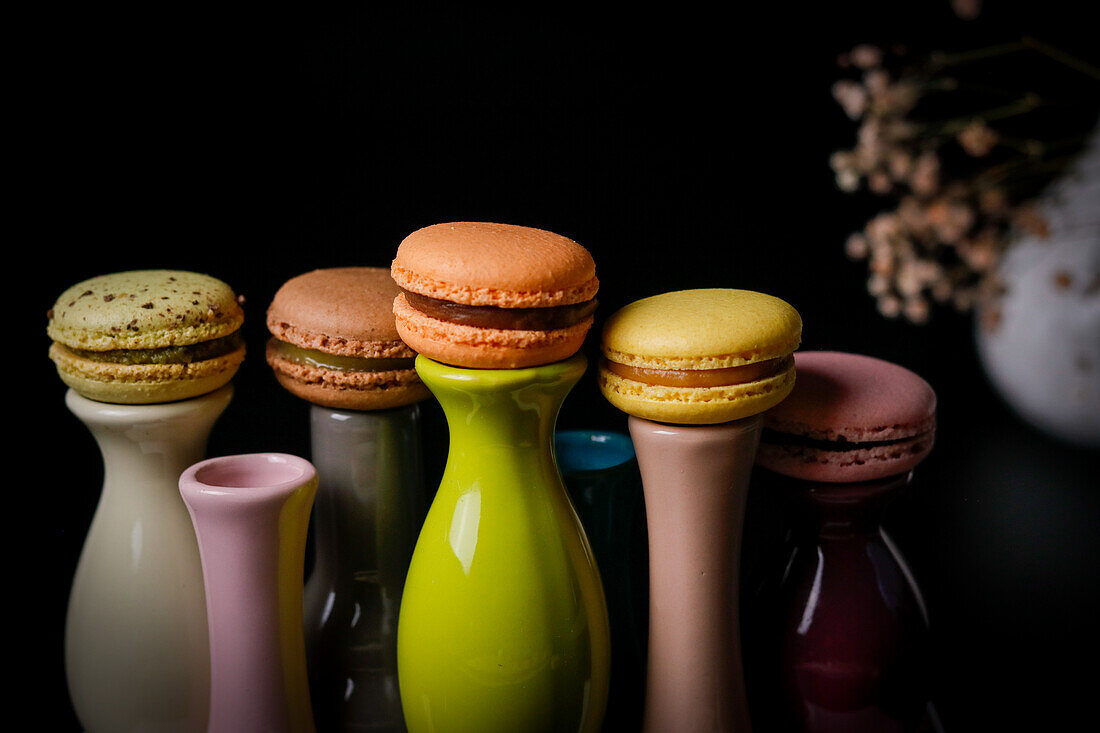 Macarons on colourful ceramic vases