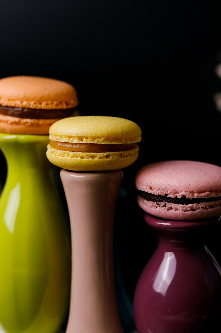 Macarons on colourful ceramic vases