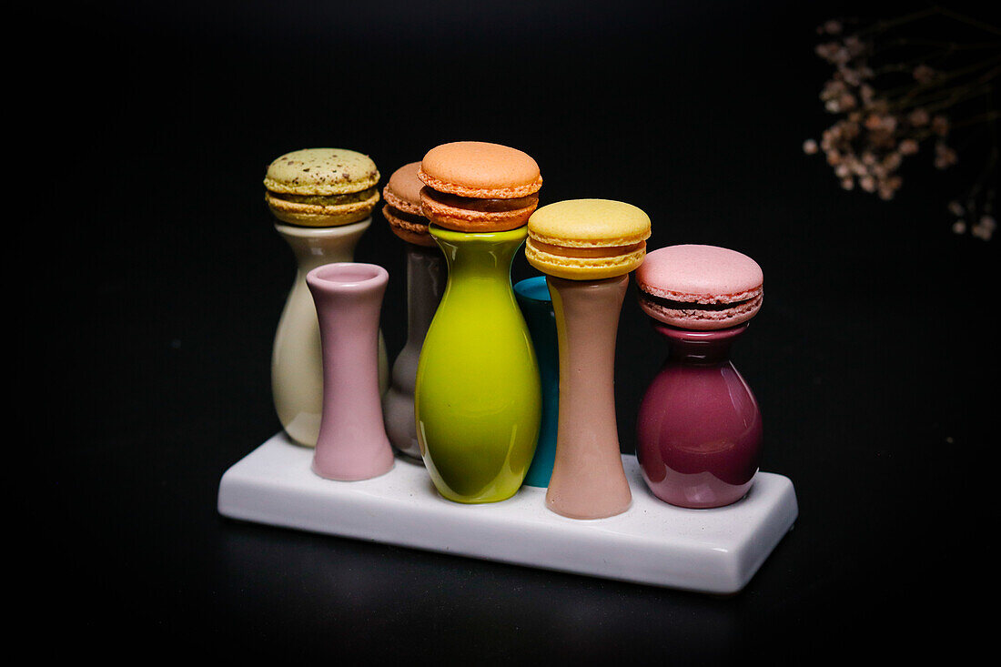 Macarons on colourful ceramic vases