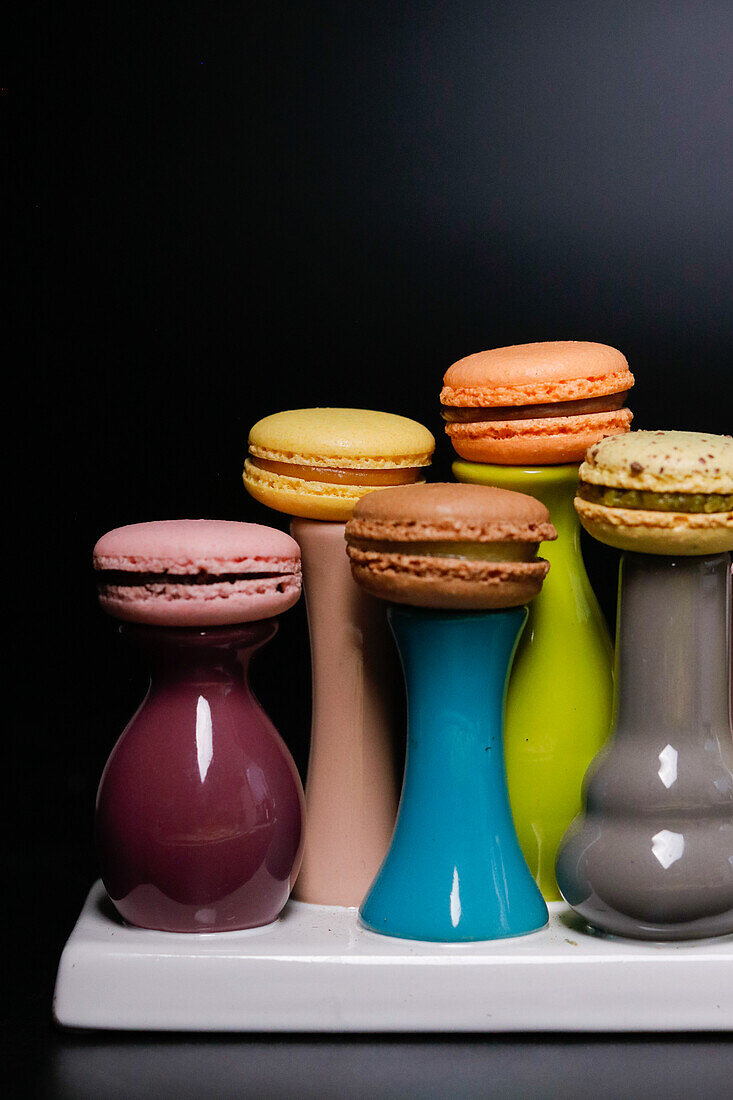 Macarons on colourful ceramic vases