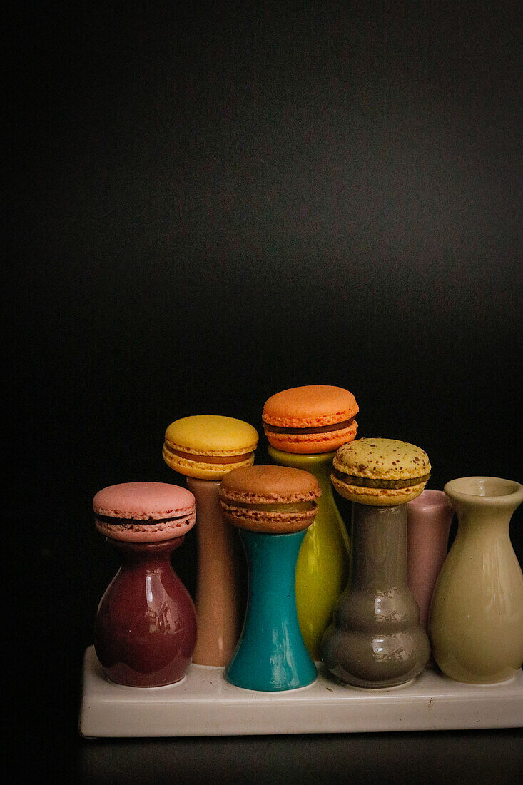 Macarons on colourful ceramic vases