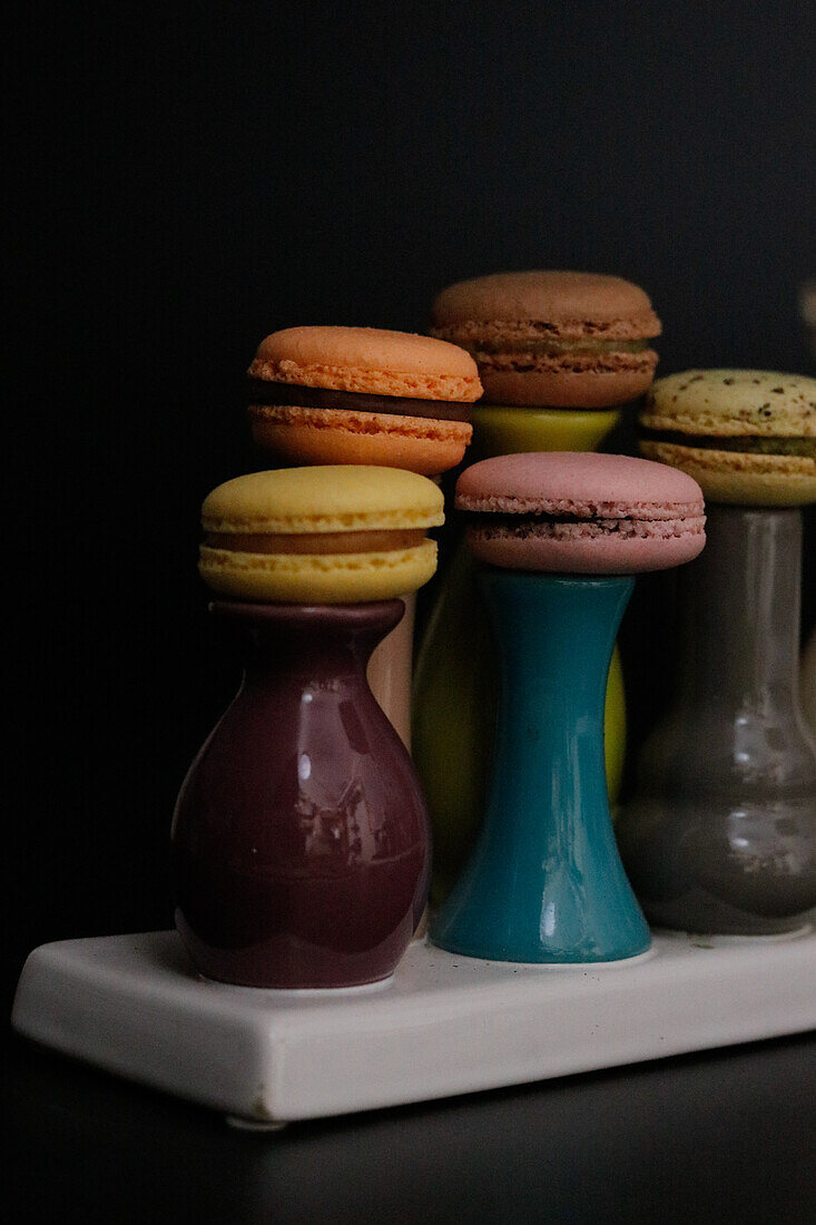 Macarons on colourful ceramic vases