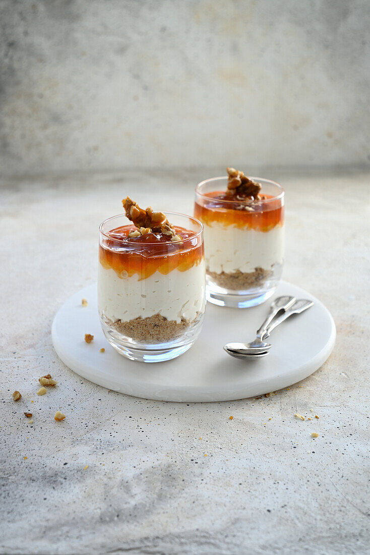 Layered dessert of cookies, whipped cream cheese, apricot jam and caramelized walnuts