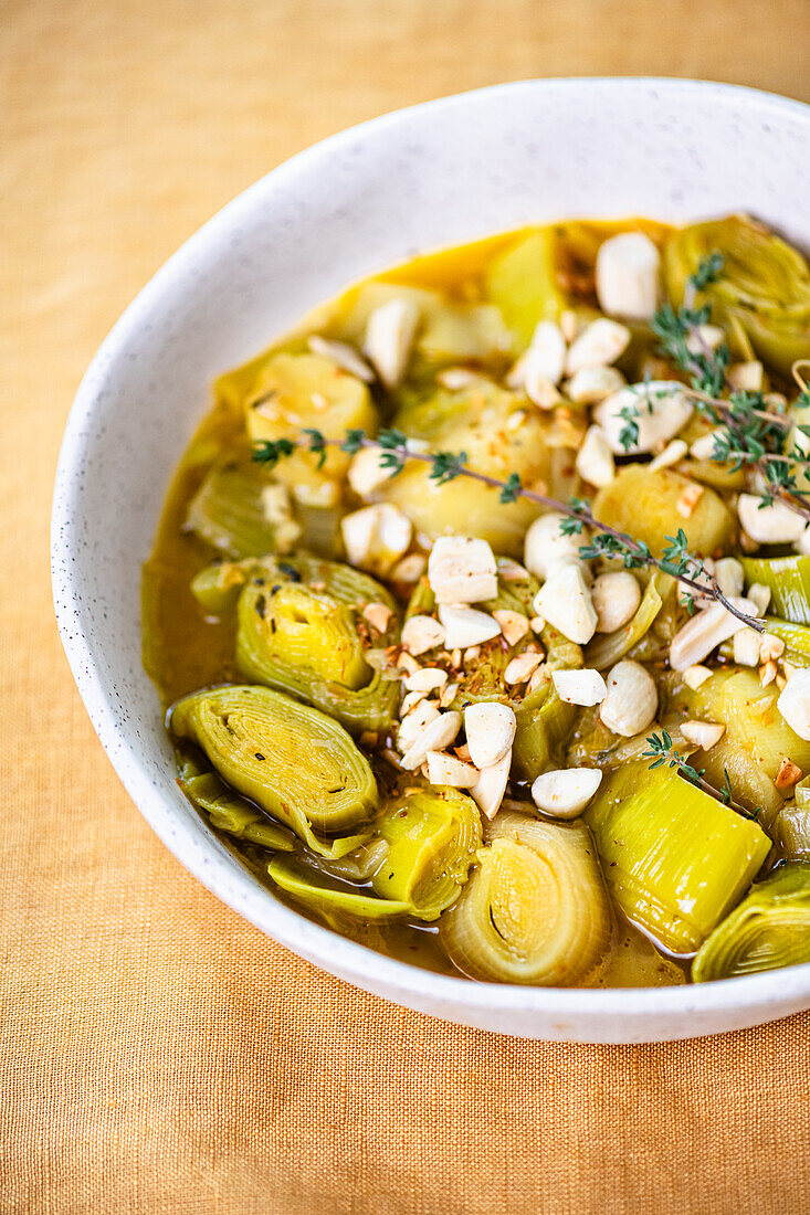 Poached leeks in white wine with garlic, thyme and almonds