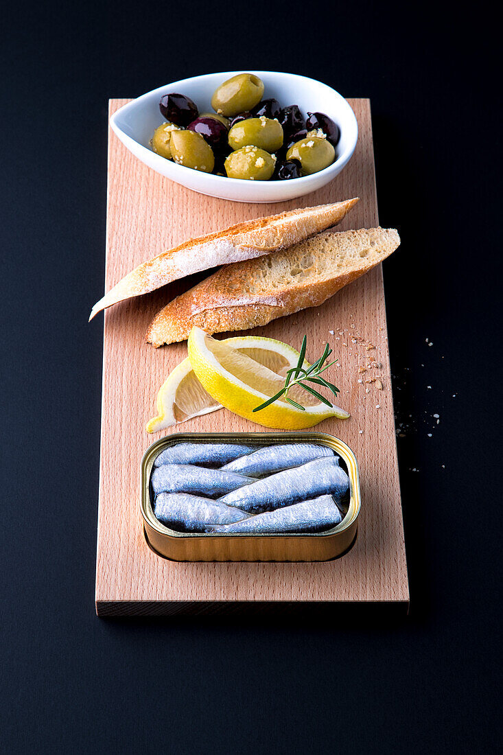 Ölsardinen, Zitronen, Röstbrot und eingelegte Oliven