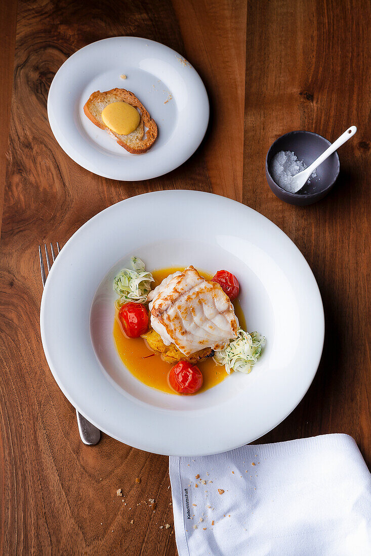 Sea bass with tomato essence, cocktail tomatoes and white cabbage