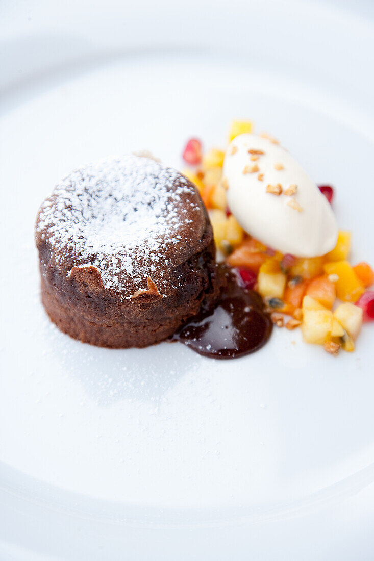 Schokoladenmuffin mit Vanilleeis und exotischem Fruchtsalat