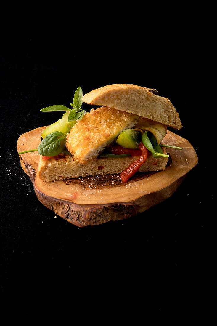 Focaccia with breaded baked cheese, green tomato and red pepper