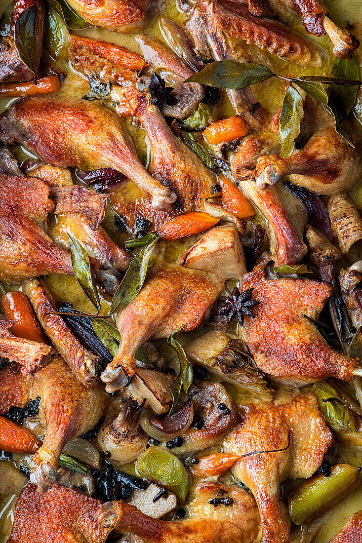 Baked chicken legs with vegetables and bay leaves