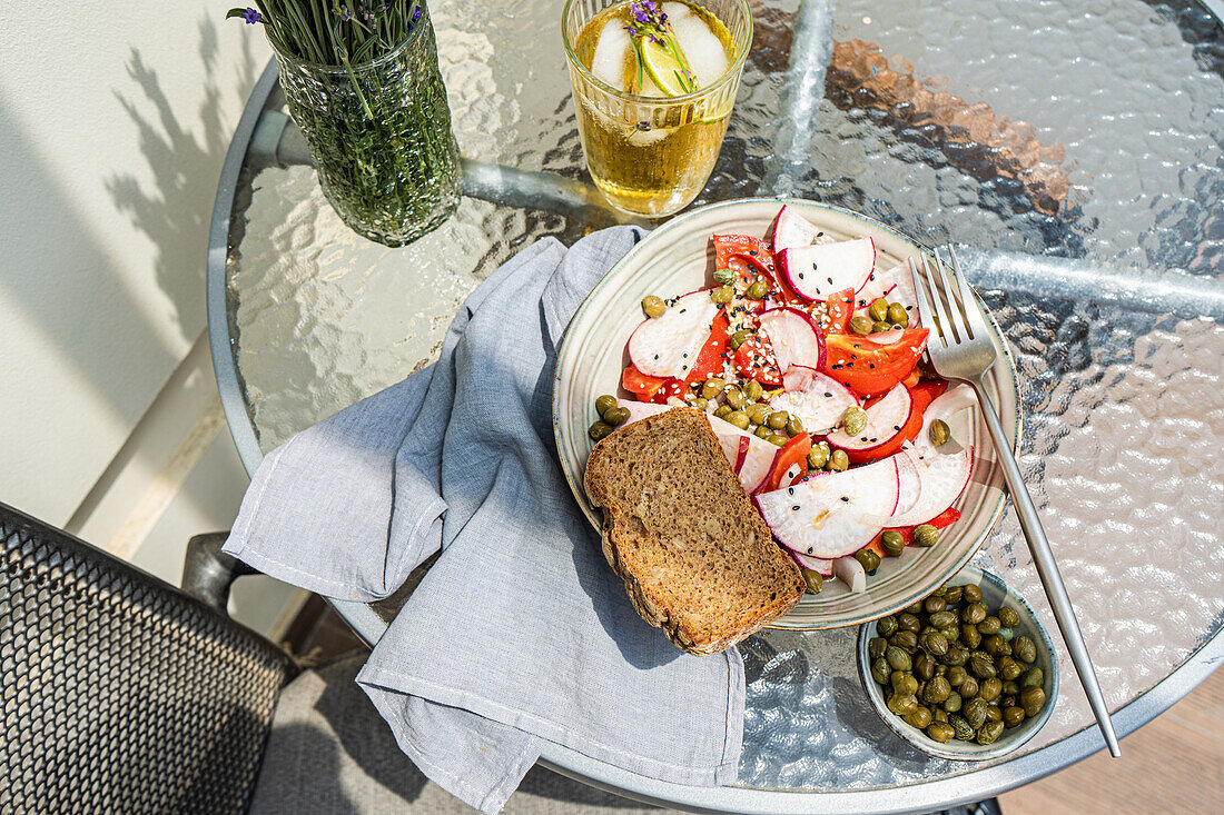 Gemüsesalat mit Bio-Tomaten, Radieschen und Kapern, dazu Limonade