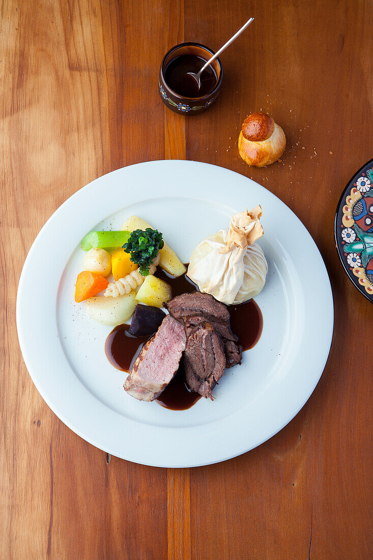 Zweierlei Schweinefleisch mit Bratensauce und Gemüse