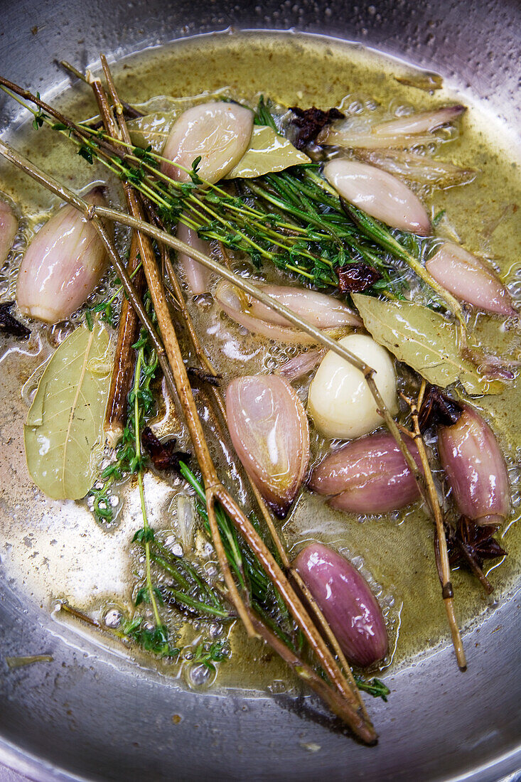 Schalotten mit Kräutern und Gewürzen in Butter