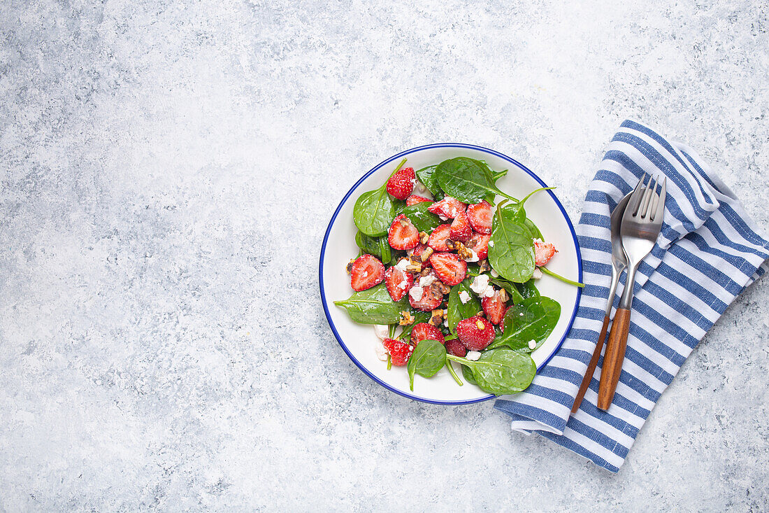 Summer salad with fresh strawberries, spinach, cream cheese and walnuts