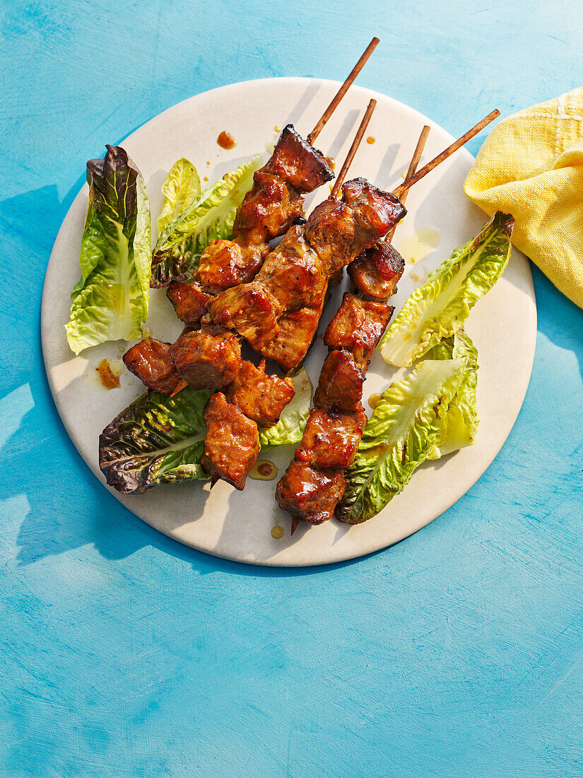 Sticky pork skewers with maple syrup and lettuce hearts