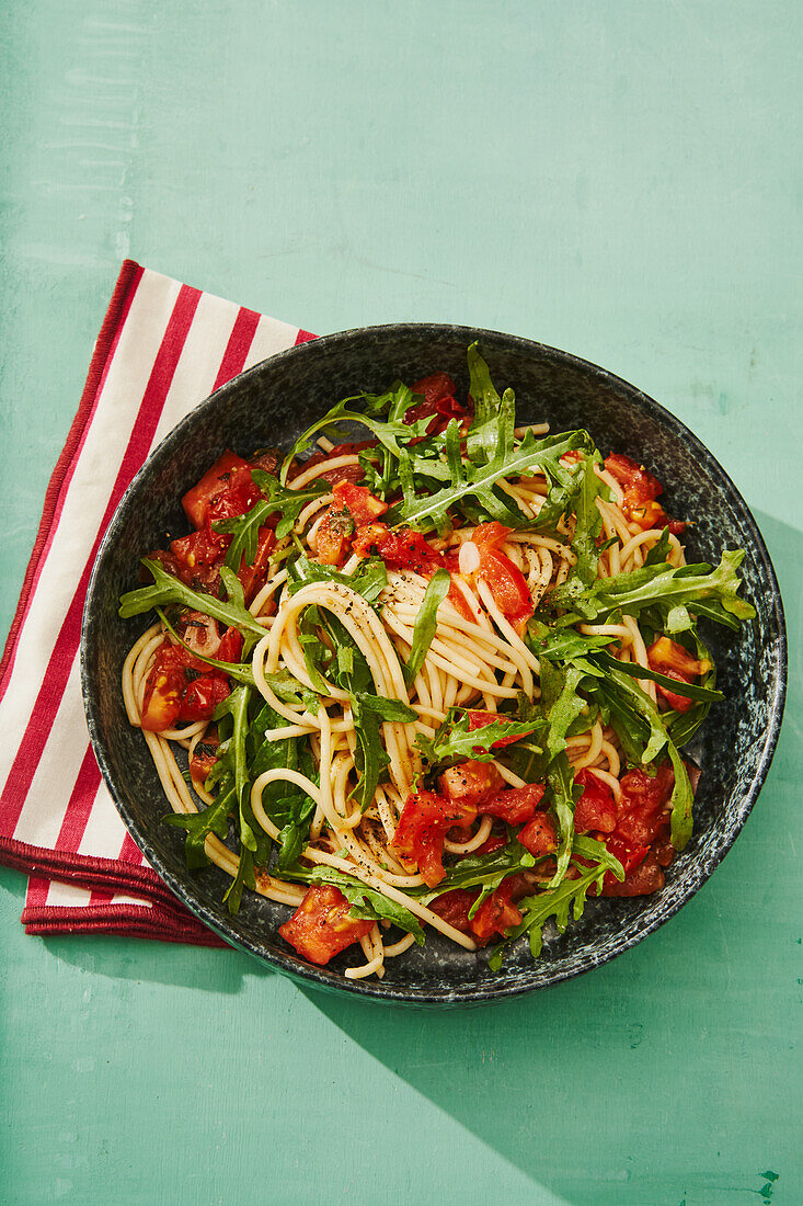 Spaghetti salad with tomatoes and arugula