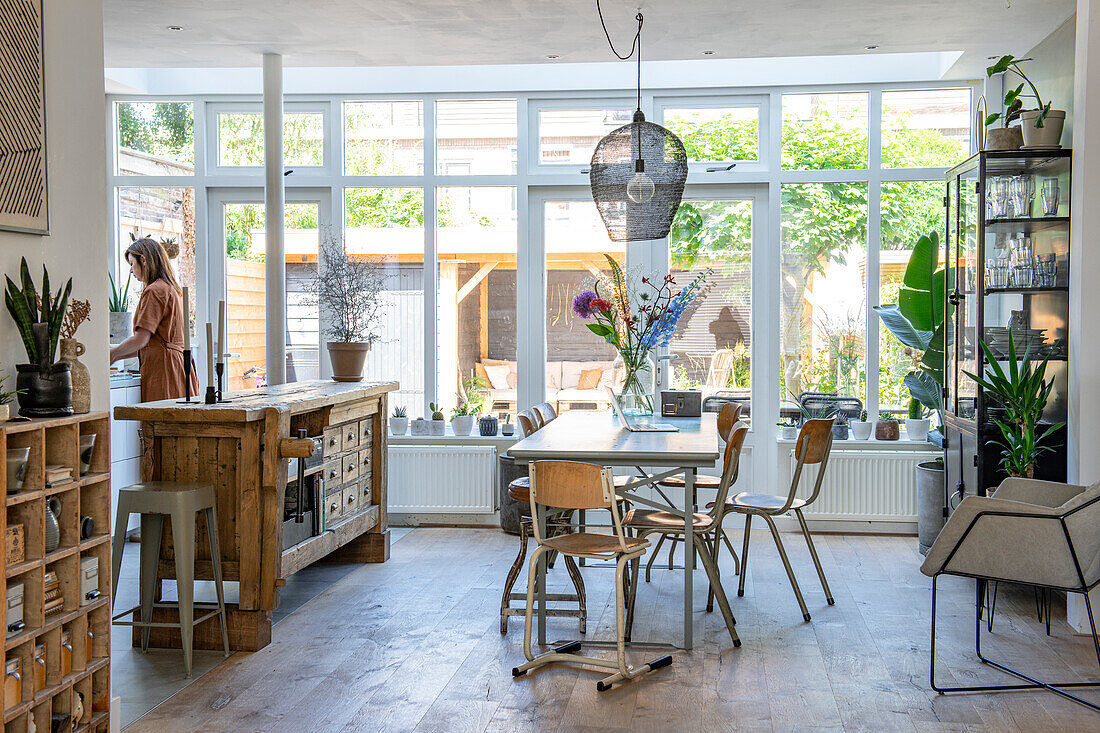 Dining area and rustic kitchen island in a bright living room with large windows