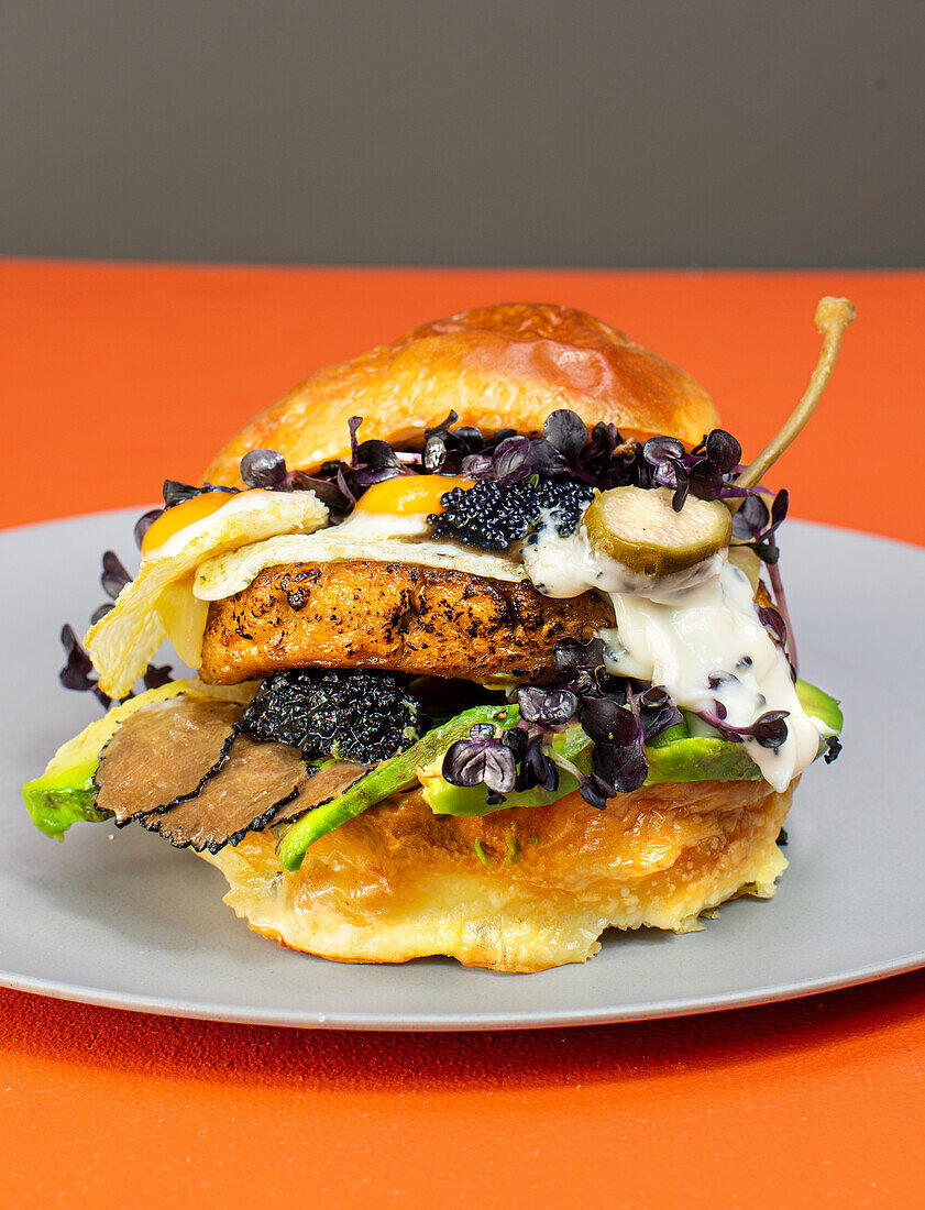 Gourmet burger with vegan patty, truffle, seaweed caviar, and quail egg