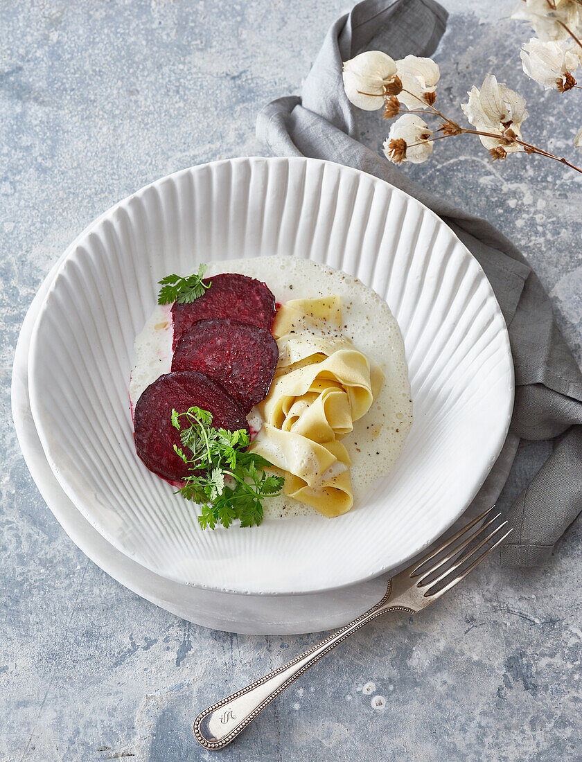 Homemade papardelle with beet and fonduta di parmeggiano