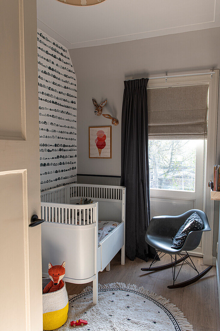 Scandinavian-style children's room with round rug and rocking chair