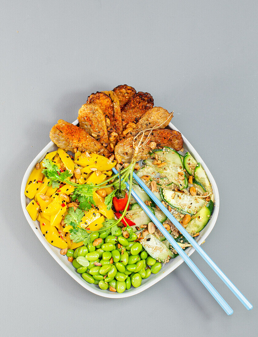 Bowl with tempeh, edamame, cucumber and mango