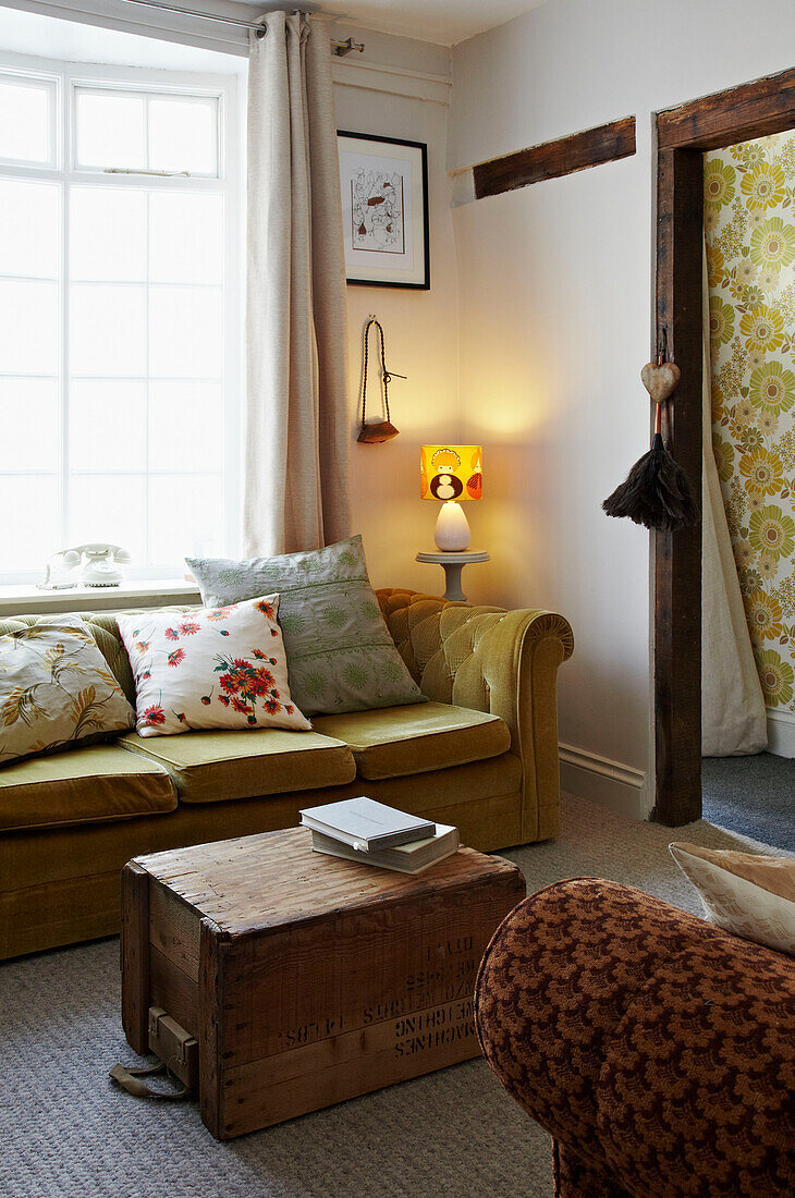 Lit lamp on side table with sofa at window of Brighton home East Sussex, England, UK