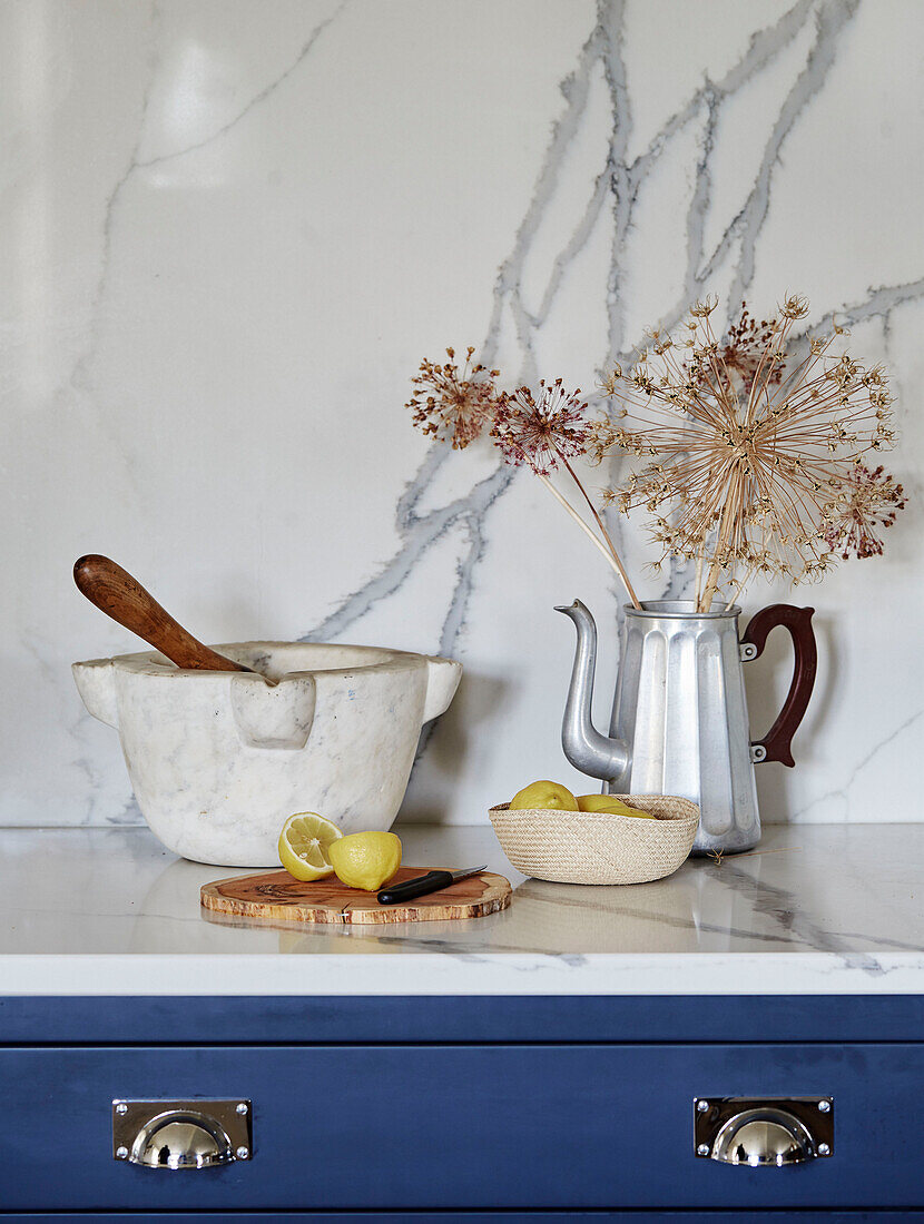 Dried flowers in coffee pot with mortar and pestle and cut lemons in North Yorkshire farmhouse kitchen, UK