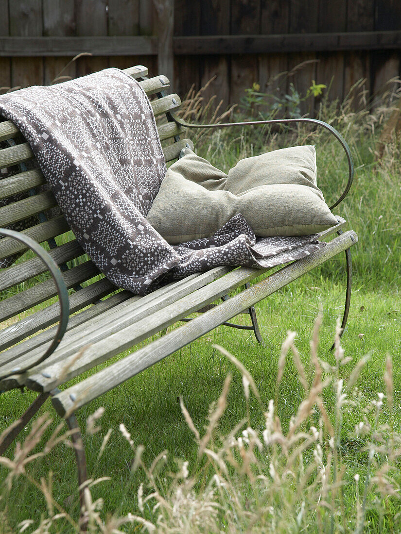 garden bench with blanket and cushion