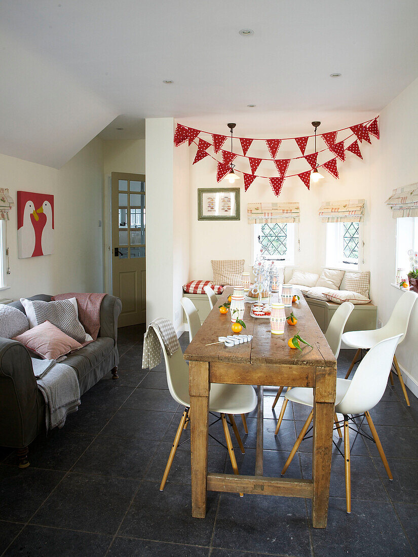 Festive bunting hangs above table in the kitchen in Herefordshire cottage, England, UK