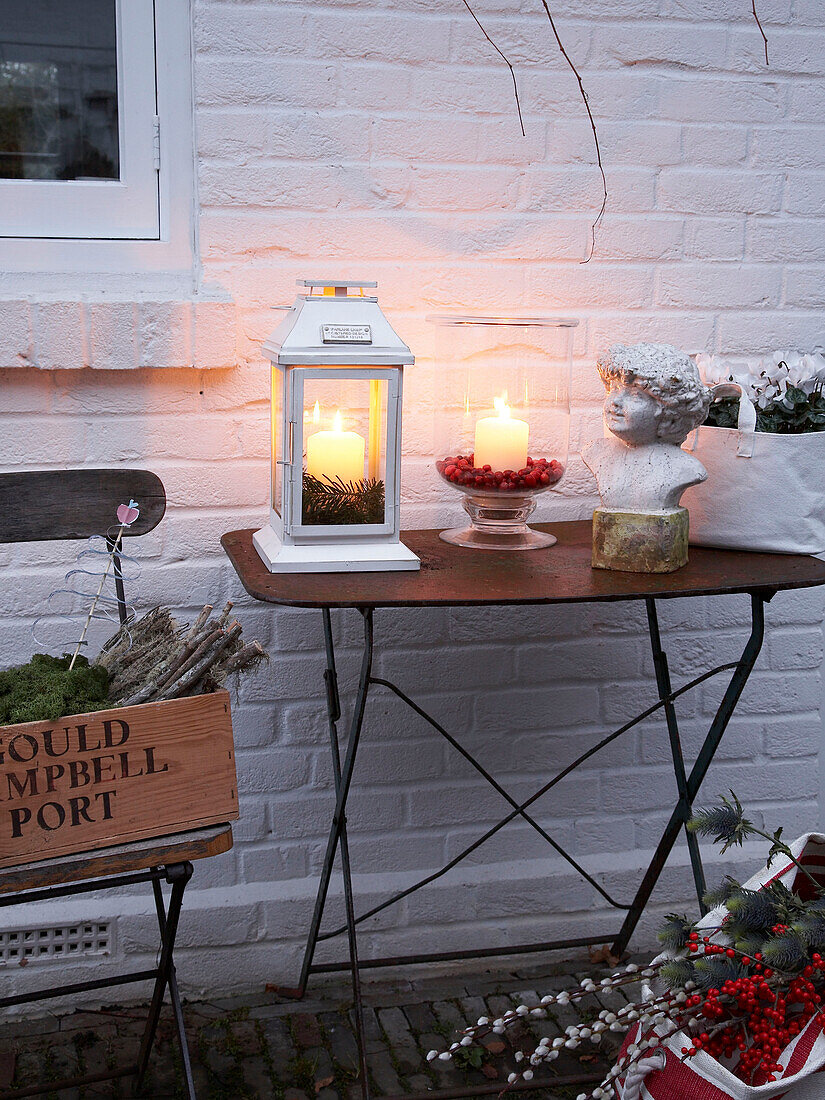 Cut flowers and lit lantern on table of Herefordshire garden exterior England, UK