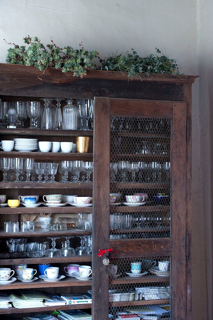 Rustic old cupboard full of crockery