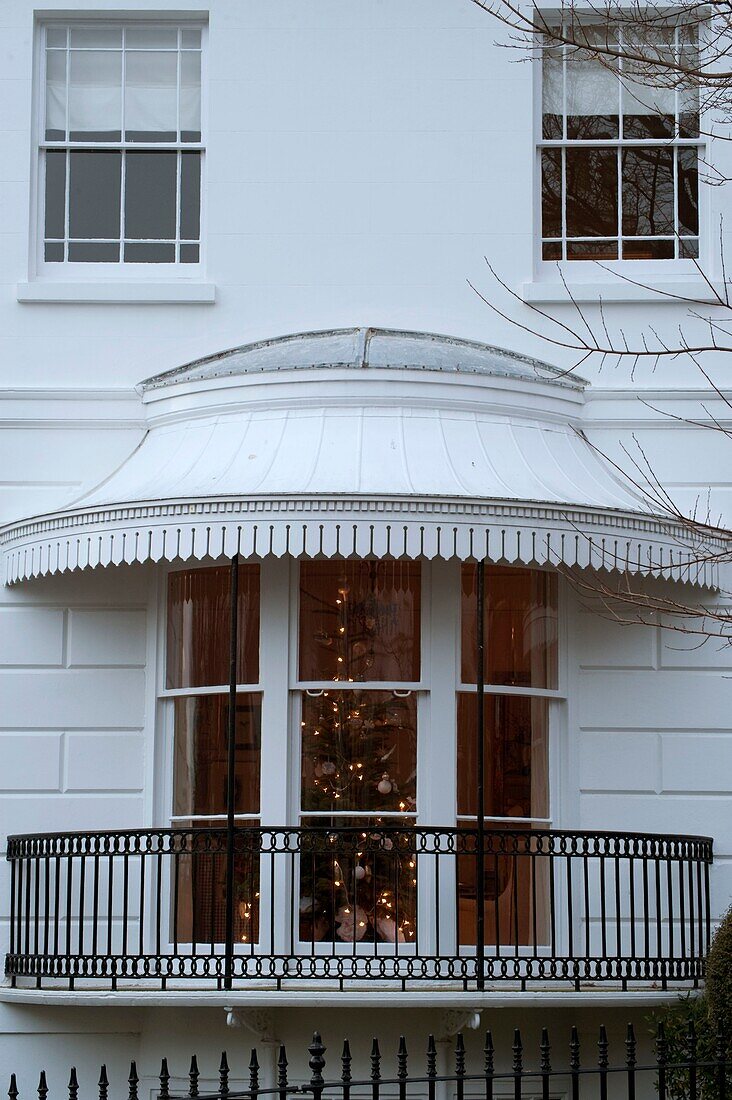 Beleuchteter Weihnachtsbaum im Hausfenster