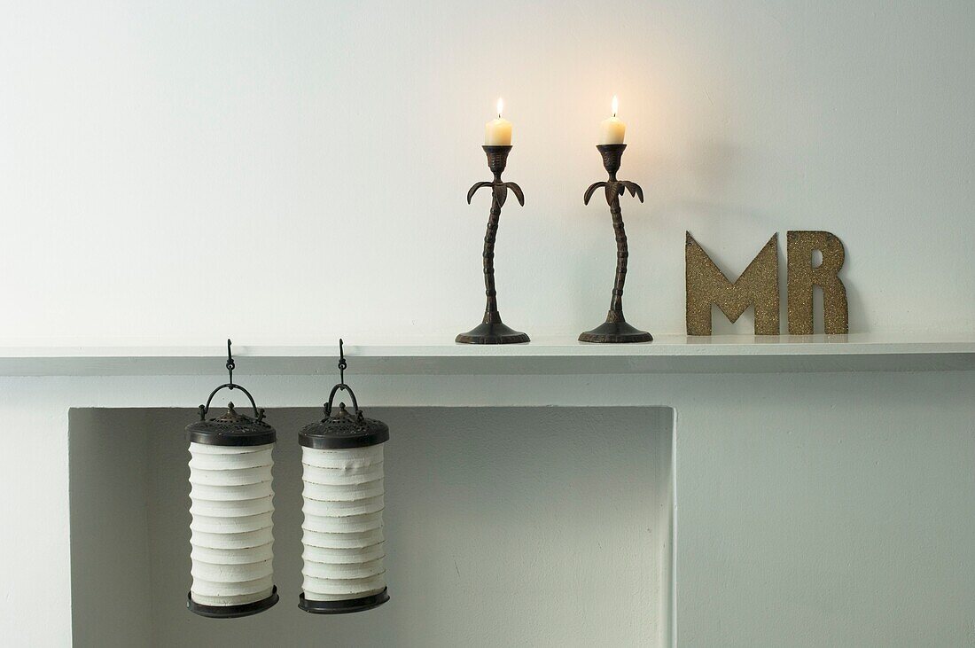 Shelf with burning candles and lanterns