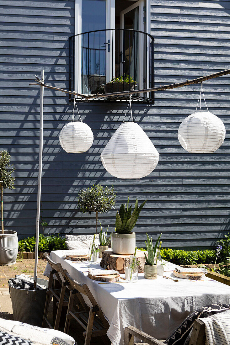 Solarlaternen über einem Tisch auf einer Terrasse mit holzverkleidetem Balkon Colchester Essex UK