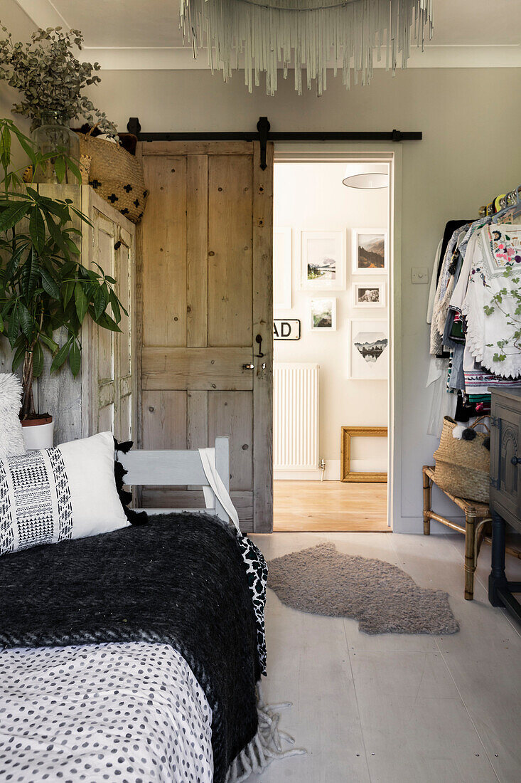 Reclaimed sliding door with daybed and clothes rail in Colchester home, Essex, UK