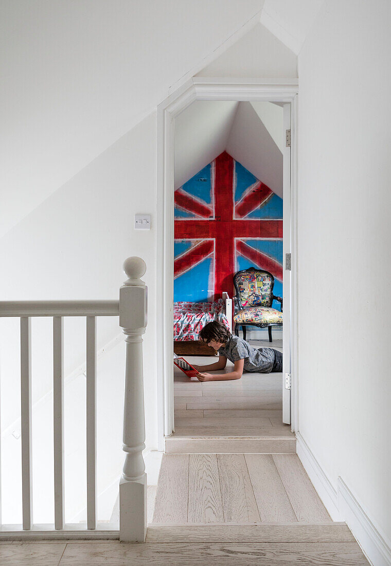 View through landing doorway to bright Union Jack in boy's room of Guildford home Surrey UK