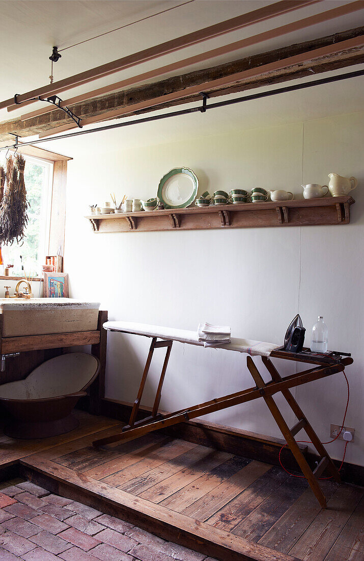 Old fashioned ironing board and laundry airer in utility room of Iden farmhouse, Rye, East Sussex, UK