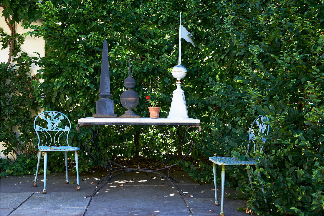 Table and chairs with ornaments in garden of Massachusetts home, New England, USA