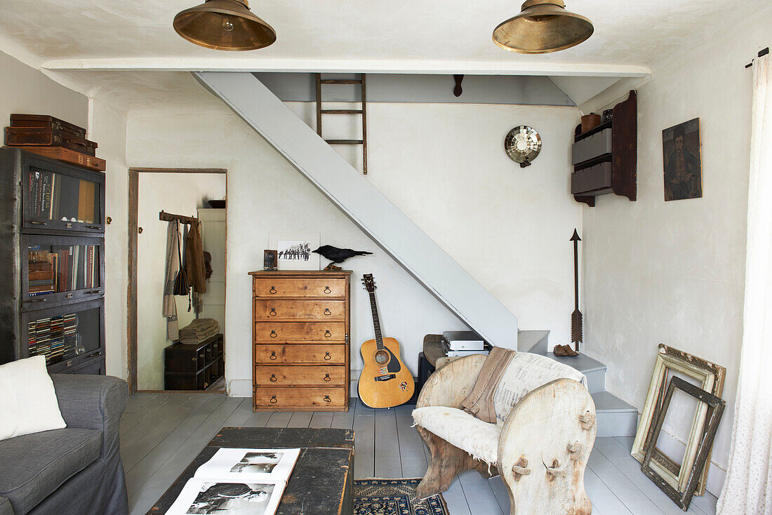 Aufbewahrungsschrank im Wohnzimmer mit offener Treppe in einem Cottage in Hastings, East Sussex, England, UK