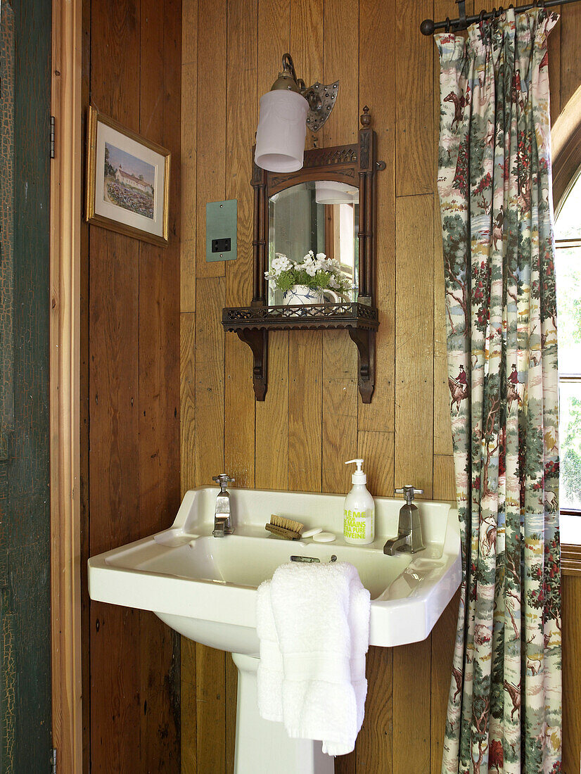 Pedestal base wash basin in wood panelled bathroom of Shropshire chapel conversion England, UK