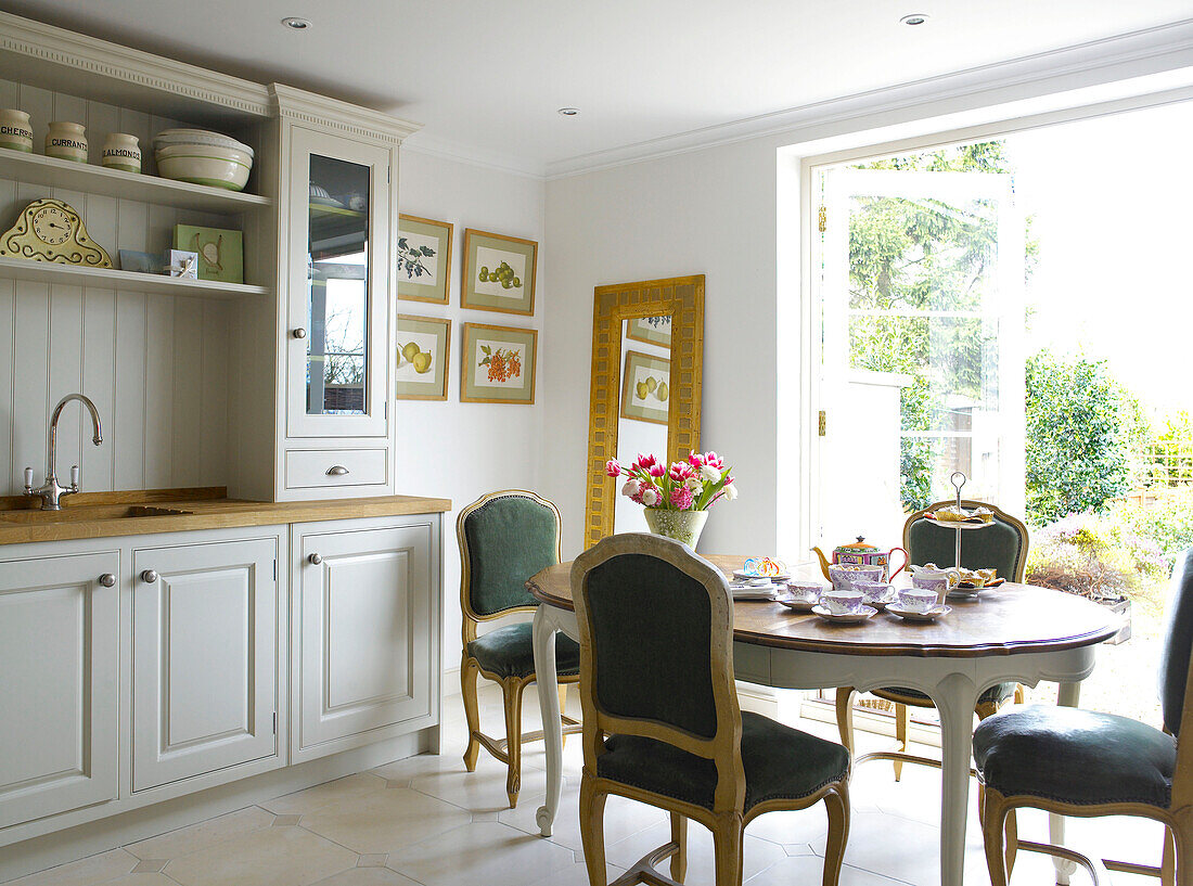 Teaset on dining table with chairs in kitchen city of Bath home Somerset, England, UK