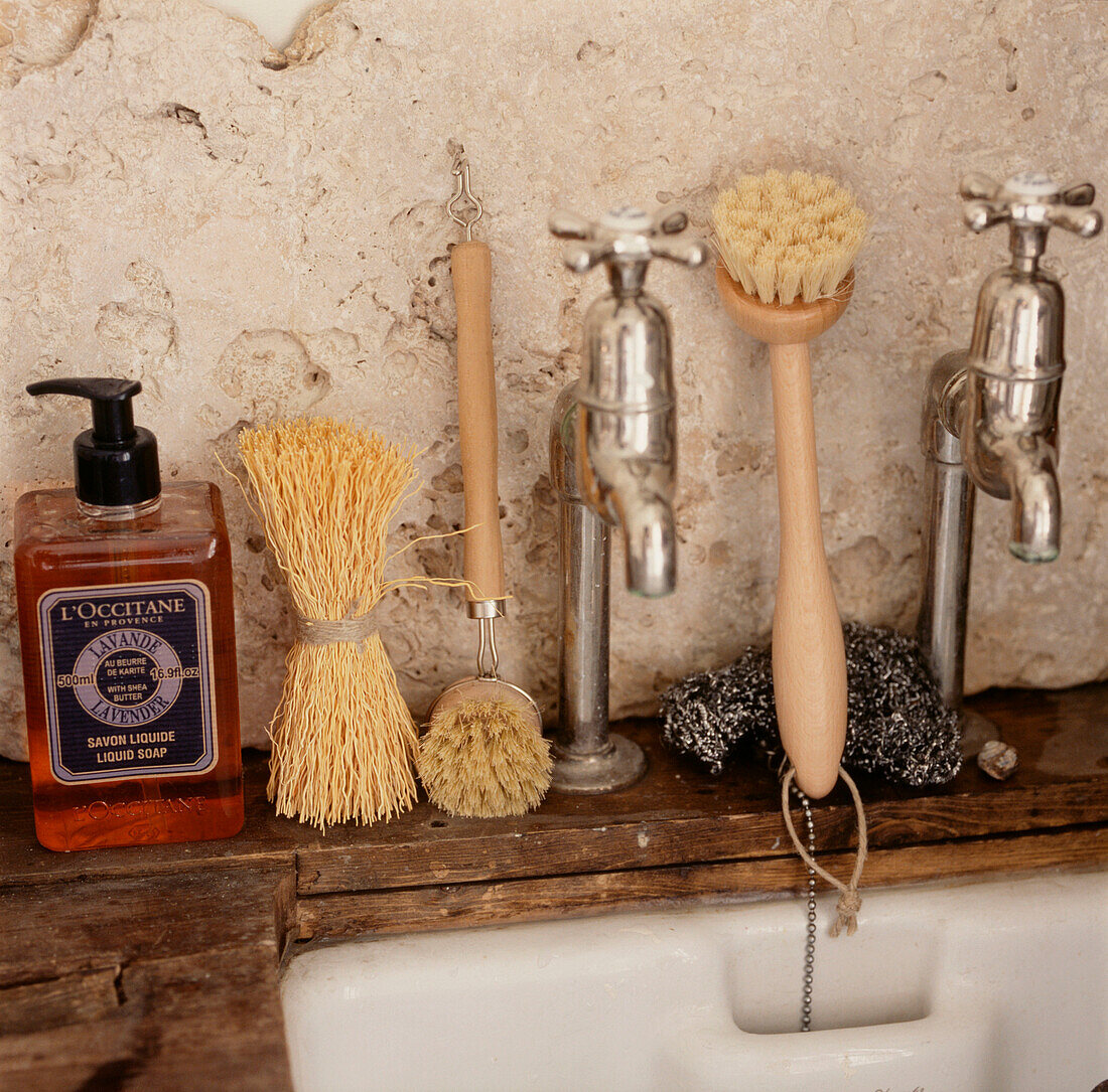 Küchenspüle und Wasserhähne mit Spülbürsten und Seife