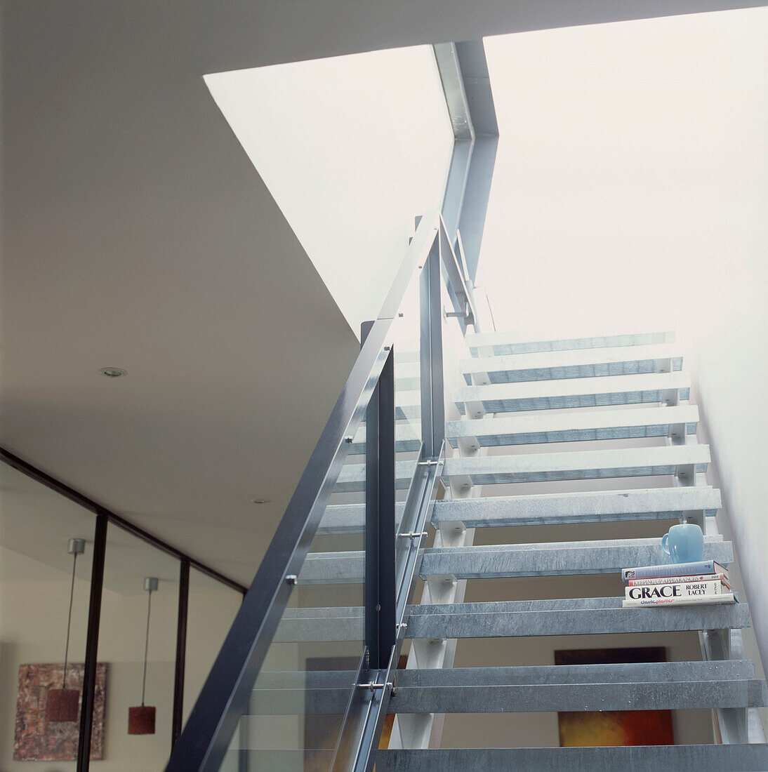 Blick nach oben auf eine Metalltreppe in einer offenen, modernen Wohnung