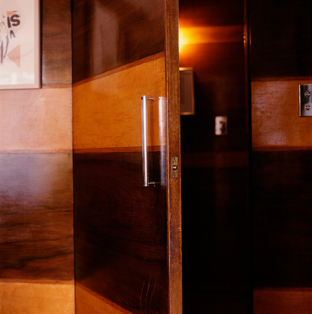 Detail of light and dark wood panelled door and wall